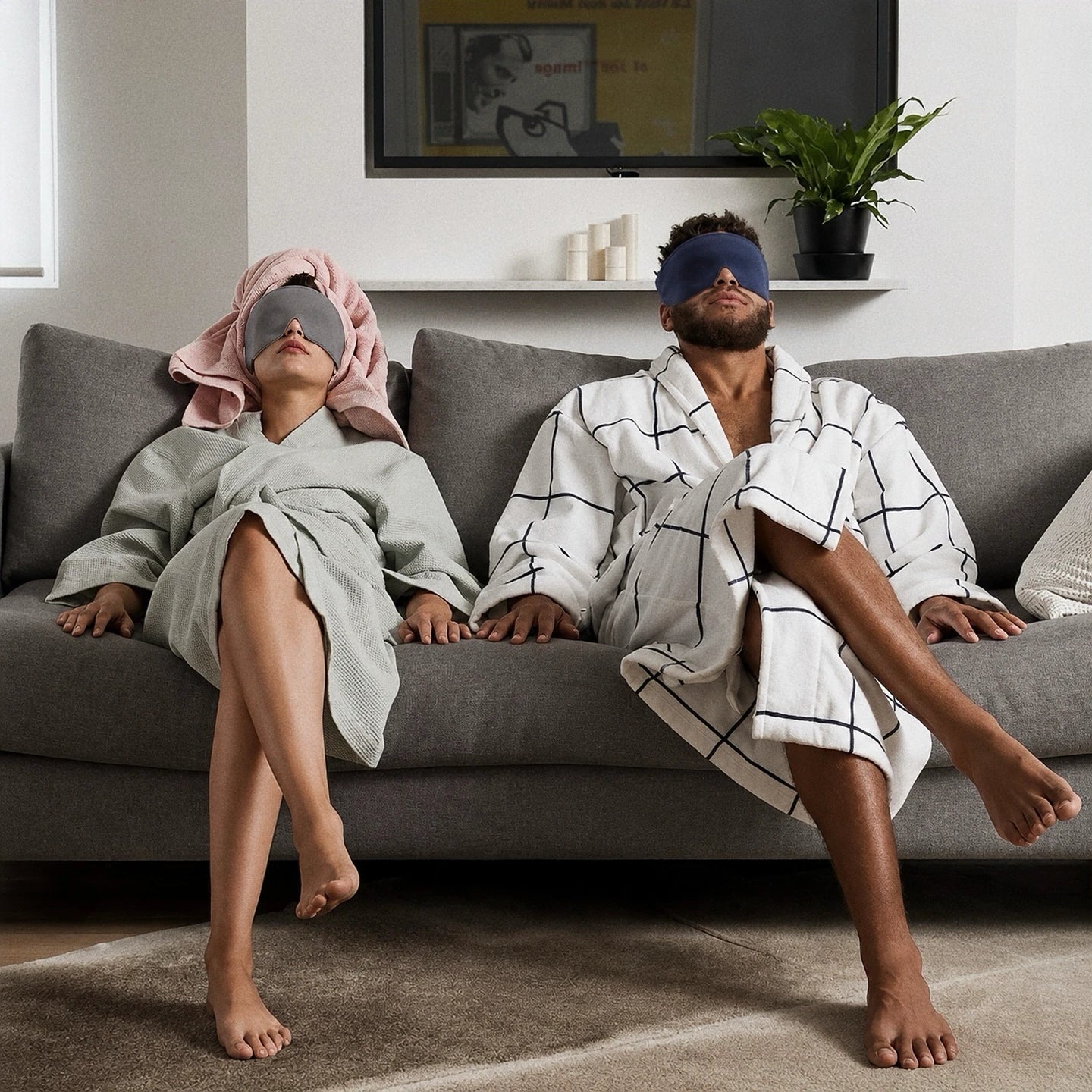 A couple resting together on a sofa while wearing Mellooa weighted sleep masks